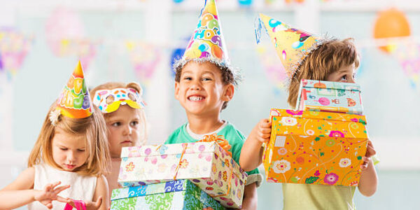 Happy children with birthday hats holding presents.